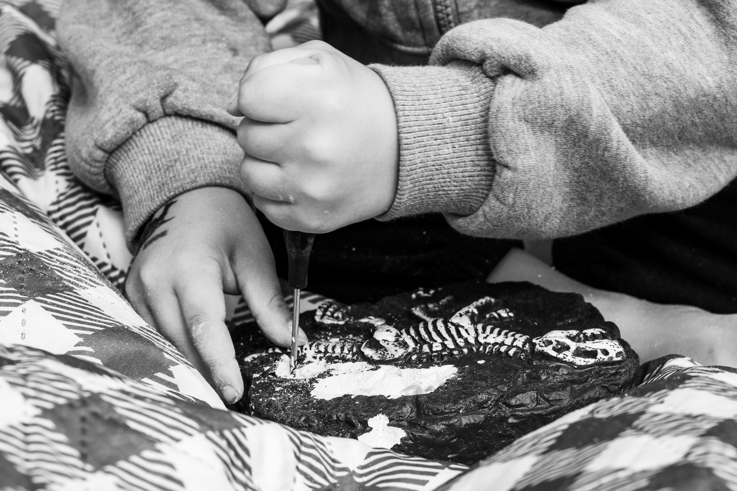 He carefully digs into a fossil